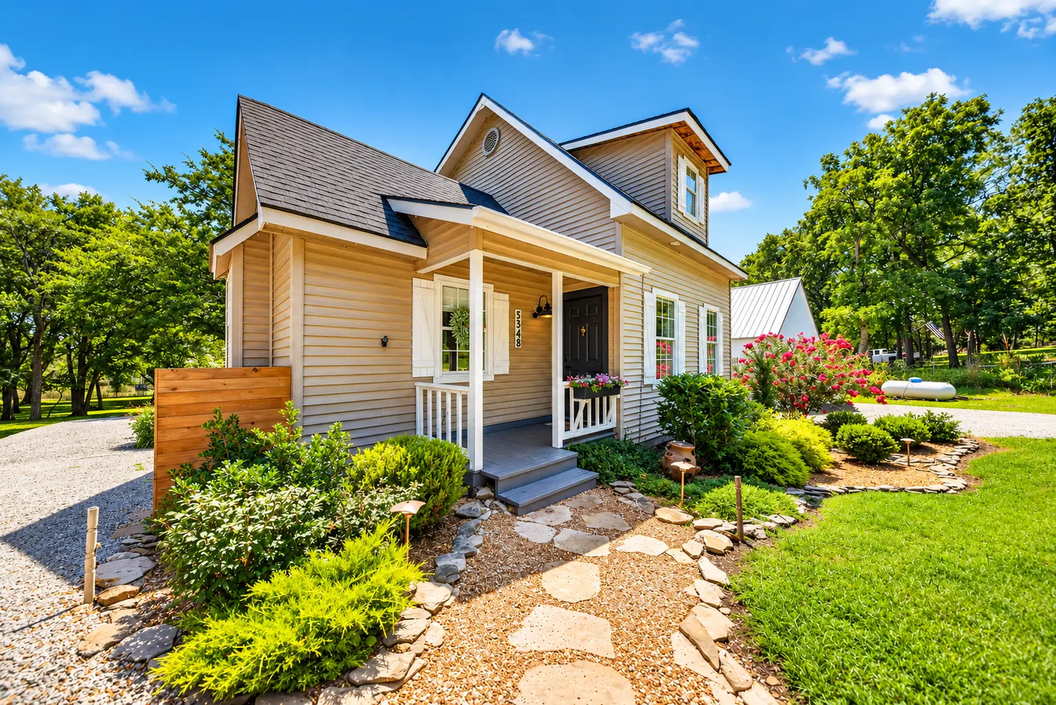 Cottage-style home exterior with covered front porch and landscaped stone walkway