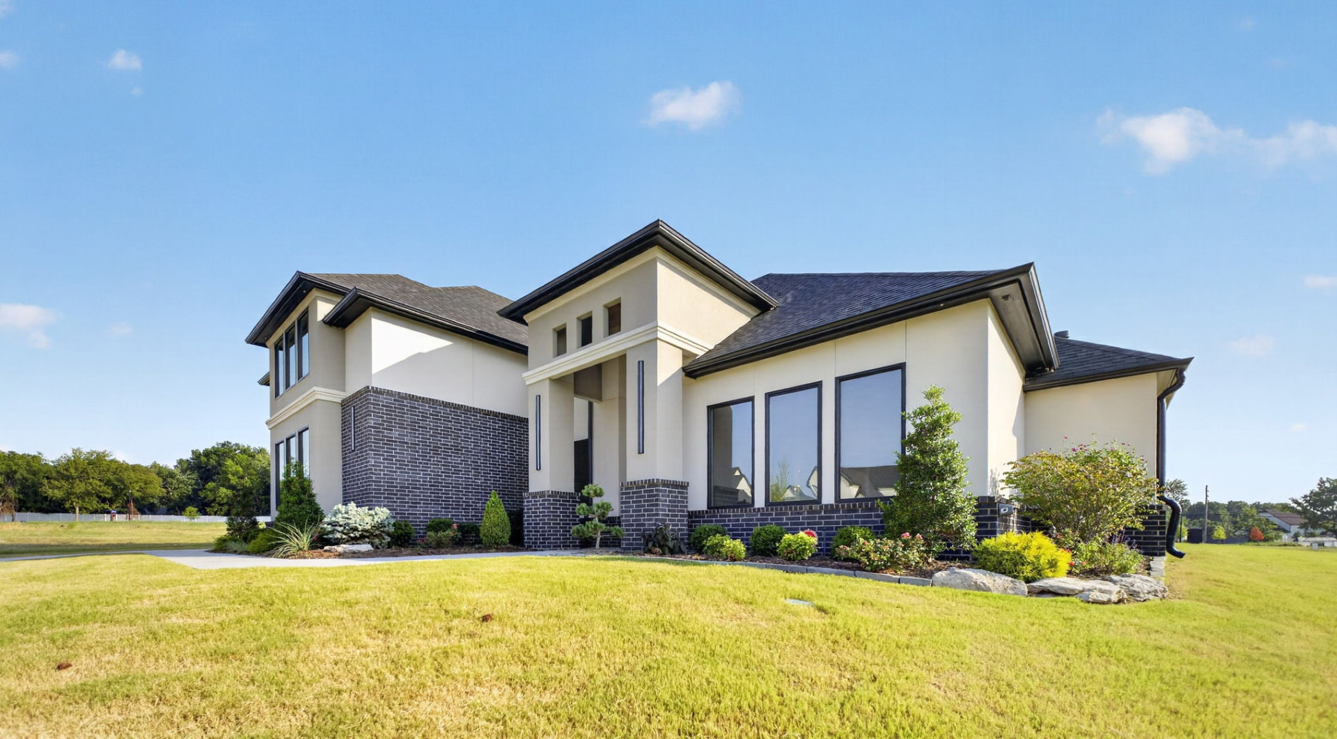 Luxury new construction home with stucco and dark brick exterior photographed in Broken Arrow Oklahoma