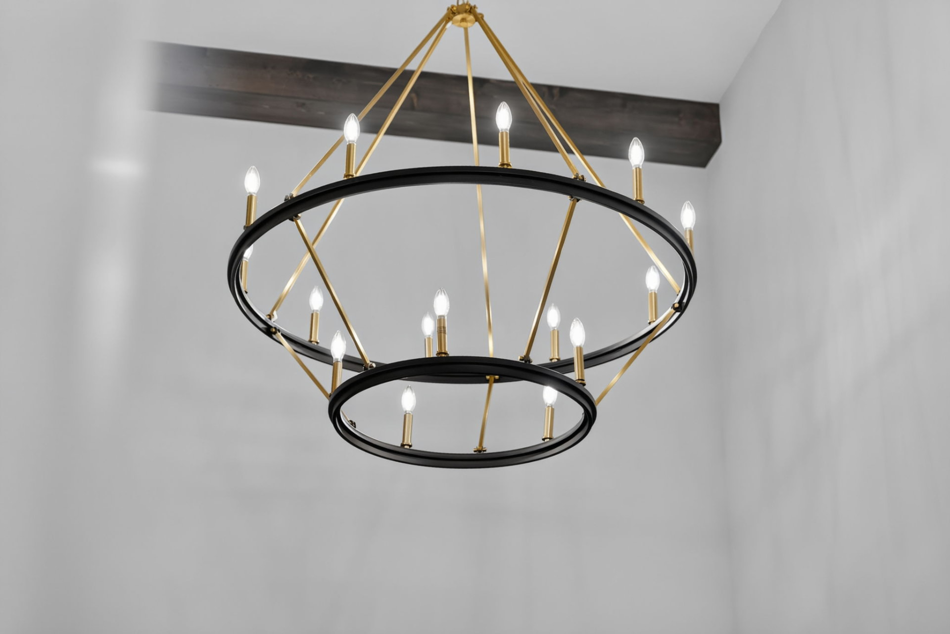 Two-tier black and brass chandelier below a stained ceiling beam in a Broken Arrow Oklahoma new construction home