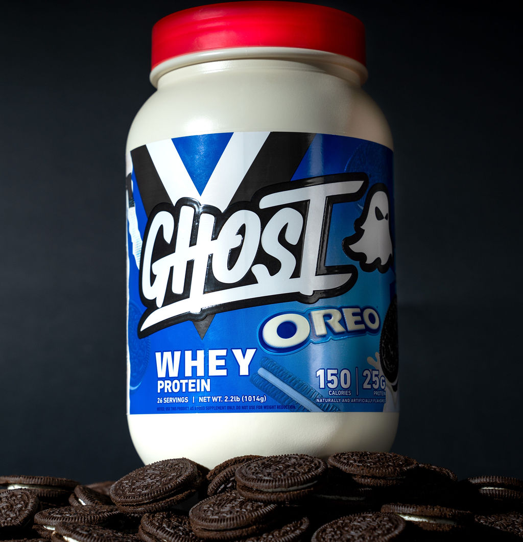 Ghost Oreo whey protein tub photographed on a bed of cookies