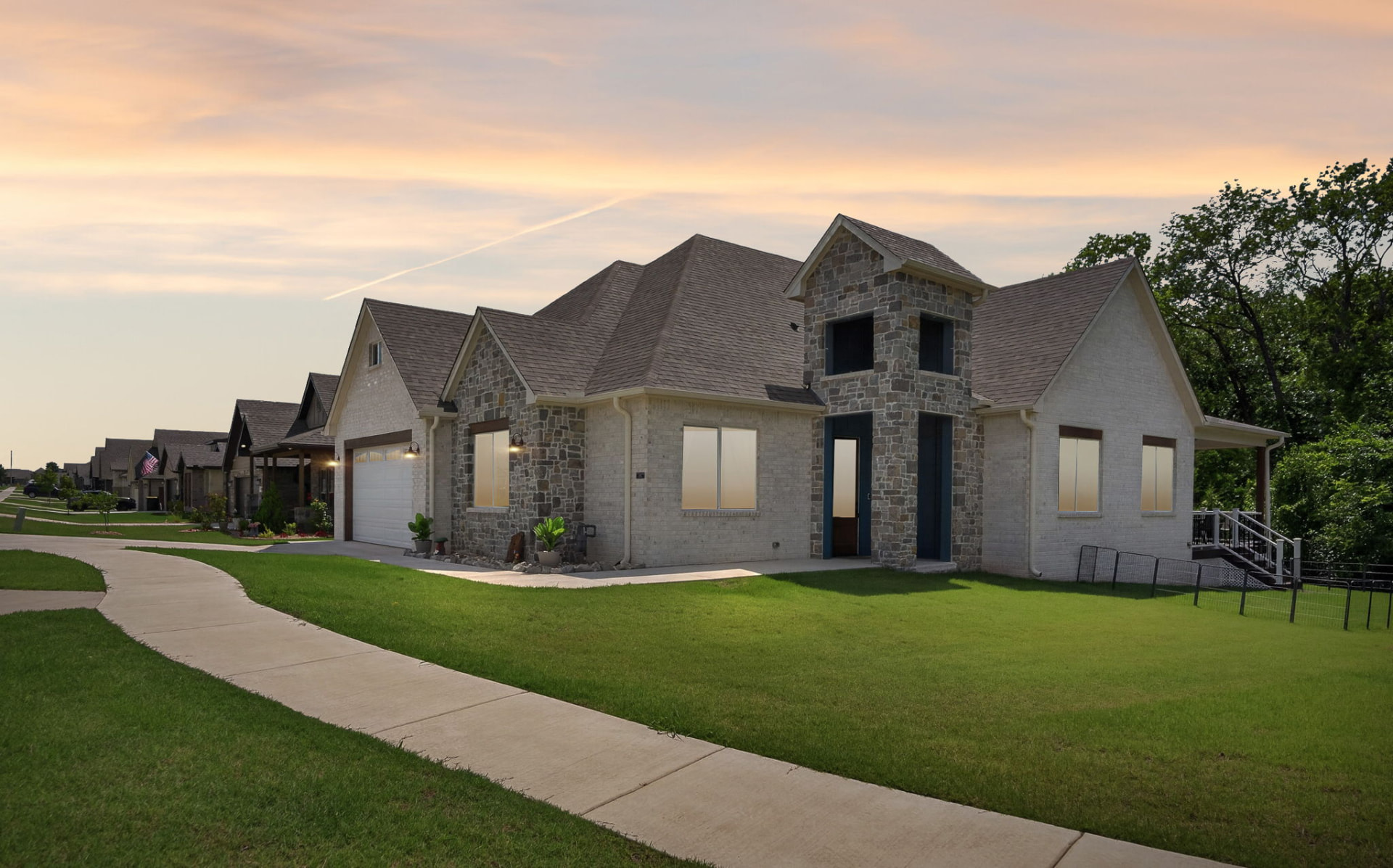 Exterior real estate photography of an Owasso Oklahoma home with stone and brick facade at dusk